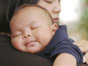 Baby sleeping on mother's shoulder
