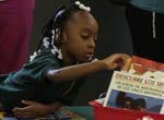 Student at Catalyst Circle Rock Charter School looking at children's books