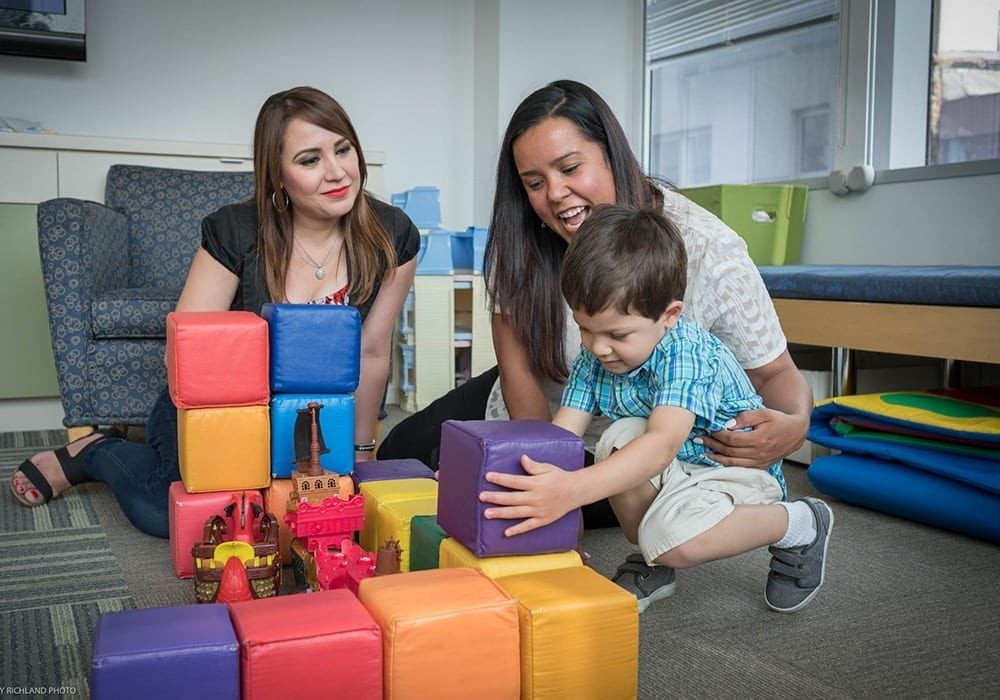 Two people playing with a child