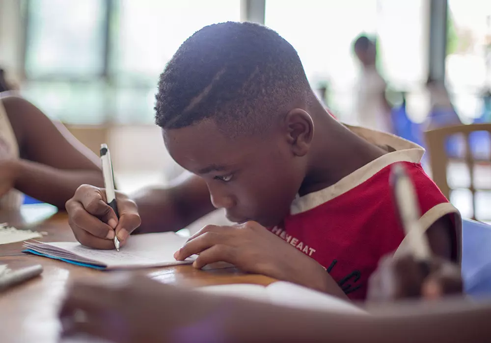 boy writing in classroom