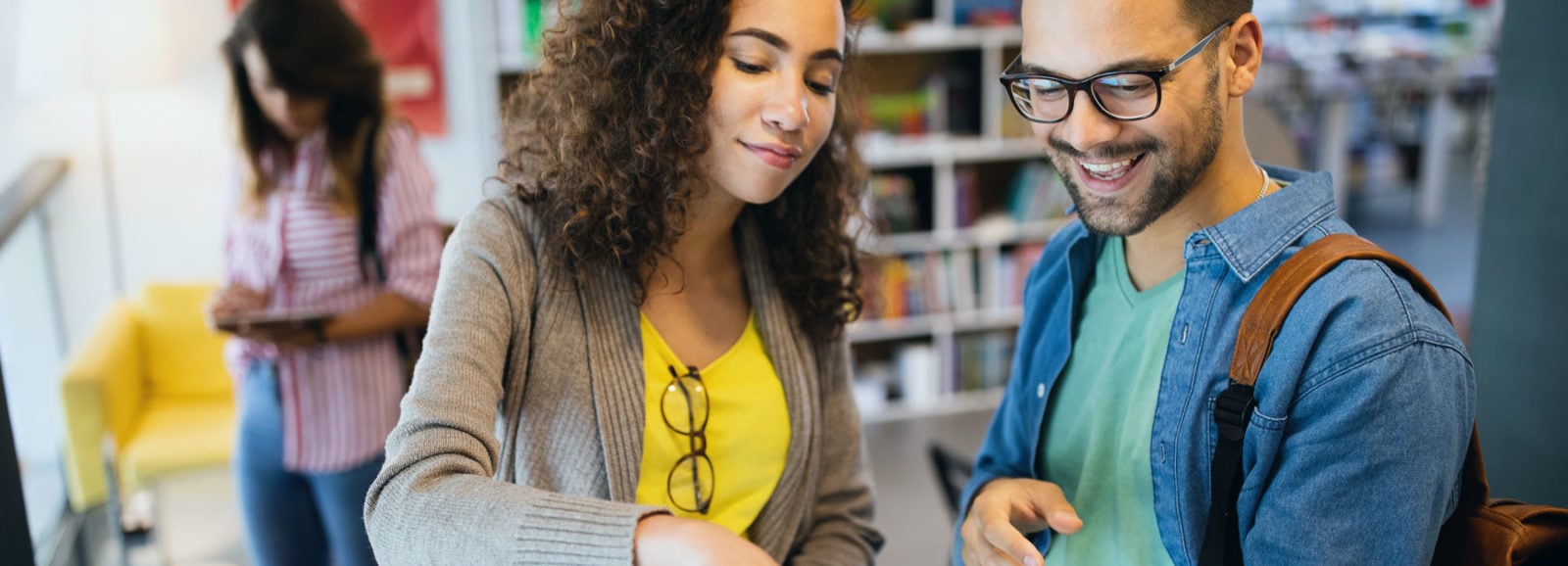 PhD candidates reviewing materials in a library.