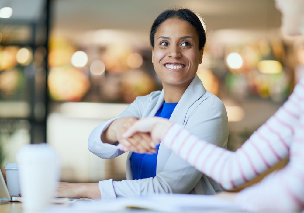 Two Master’s Degree candidates shaking hands.