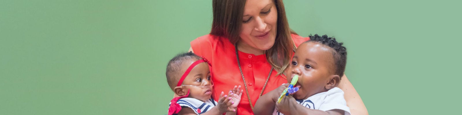 Child Life Specialist holding two babies.