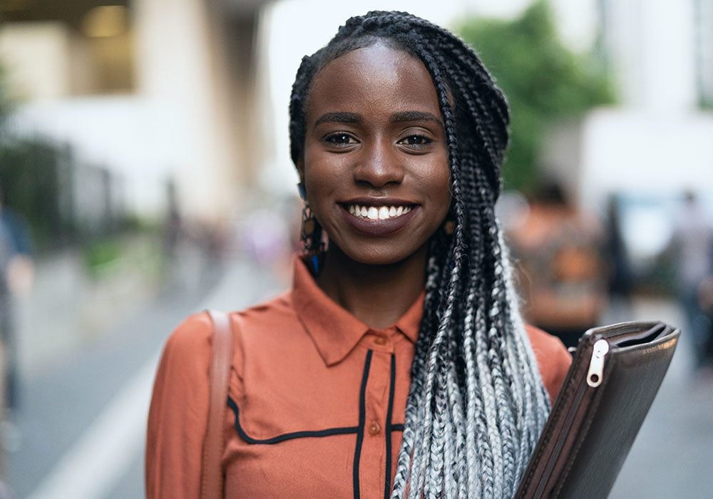 Smiling Child Development student carrying a leather portfolio.