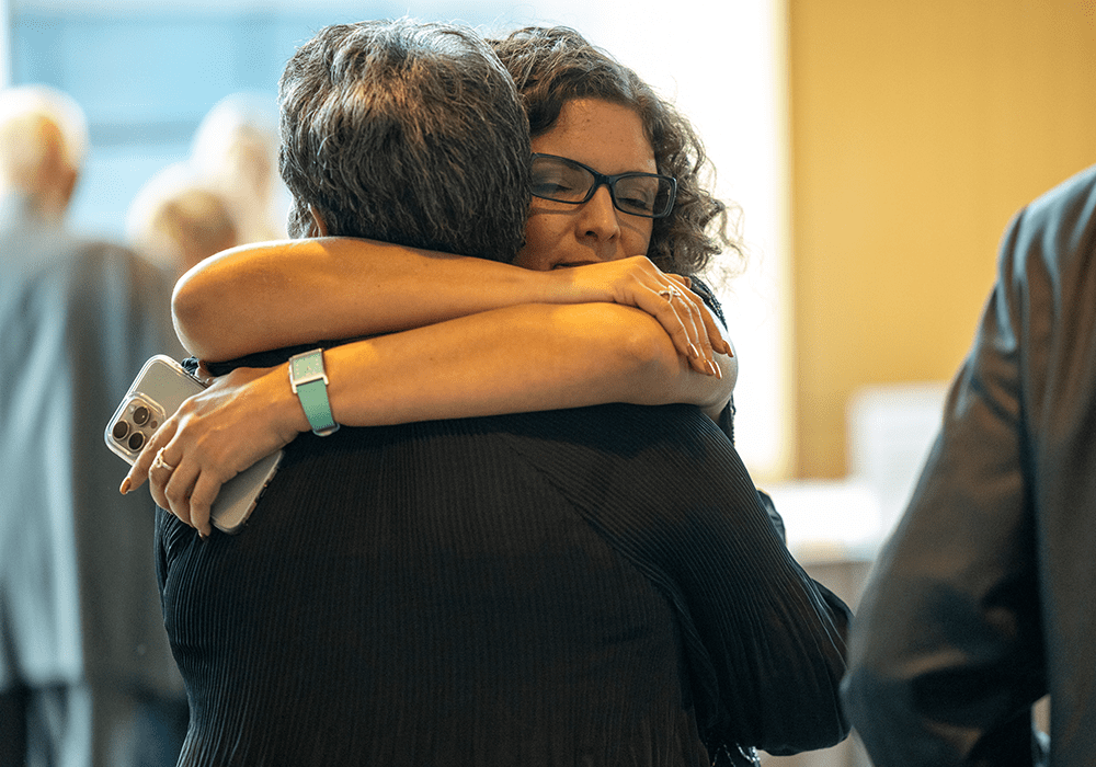 Mariana Souto-Manning hugging an attendee