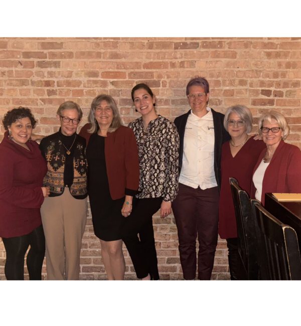 L-R, Dean of Faculty Maxine McKinney-deRoyston, Commencement keynote speaker Adele Diamond, doctoral chair Cynthia García Coll, doctoral candidate Kia Ferrera, Senior Instructor Jeanette Banashak, Associate Professor Amanda Moreno, Professor Linda Gilkerson.