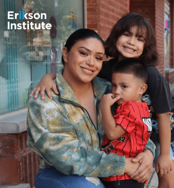 A mom smiling and holding her two children