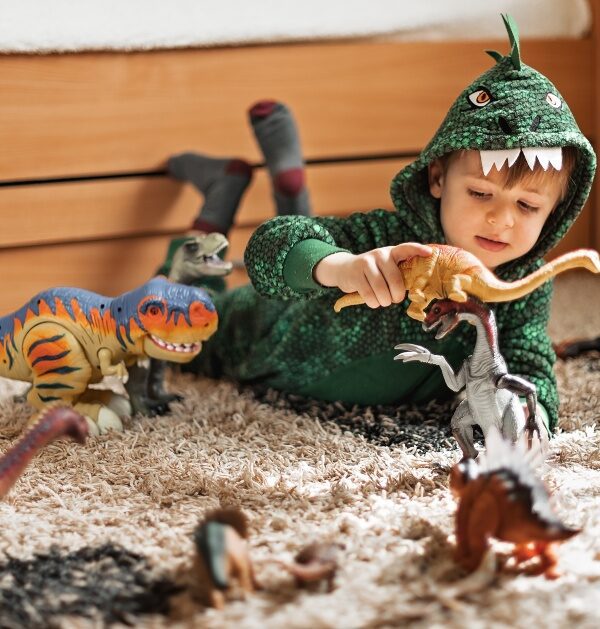 child playing dress-up in dinosaur costume