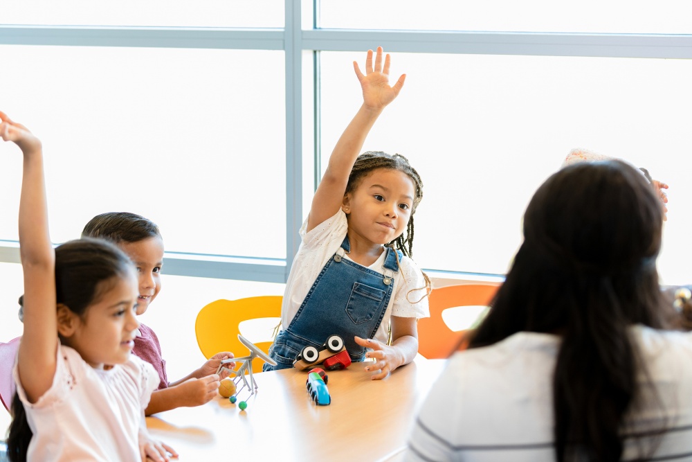 kindergarten girl raising hand classroom