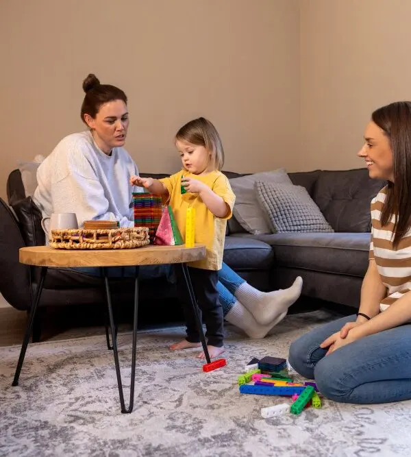 A practitioner sitting at child level with a toddler during a home visit