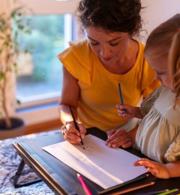 A foster parent and child engaged in a simple shared activity at home, a moment that reflects the attuned relationships this research works to strengthen
