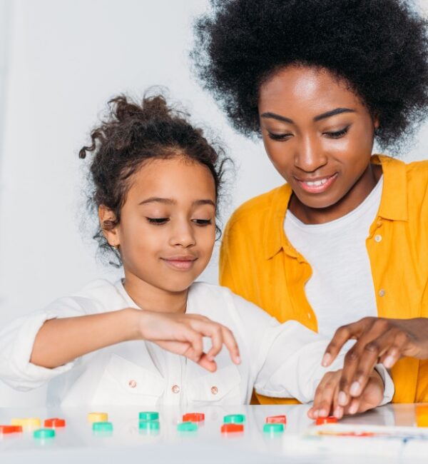 A parent and child laugh together while playing a game
