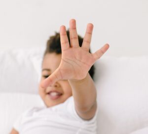 young kid putting hand up