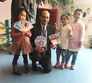 Children at an early childhood education site in China present gifts to Erikson President and Chief Executive Officer Geoffrey A. Nagle, Ph.D. Dr. Nagle and other leaders are in China to see firsthand the influence of an Erikson partnership that is training more than 1,000 early education professionals about best practices and theory.